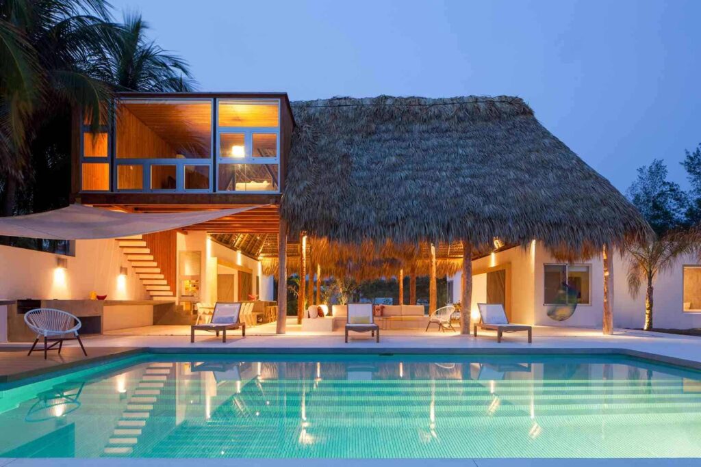Tropical resort-style front home design for 1800 yard property with lush landscaping and vacation vibe